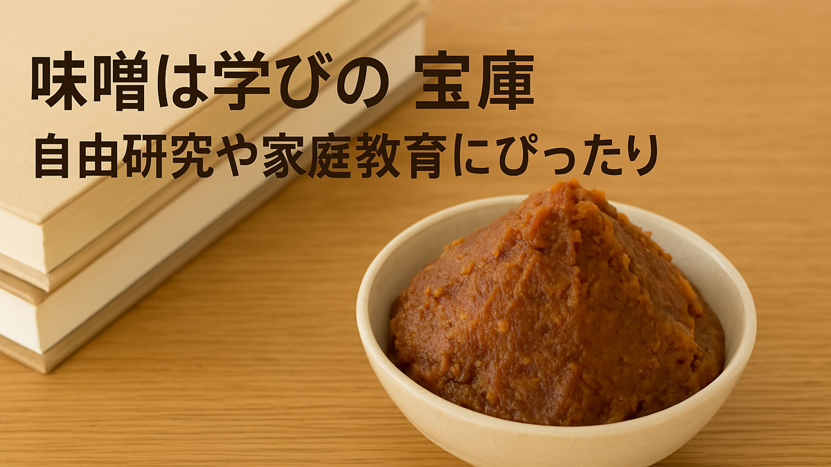 味噌が盛られた白い器と、隣に置かれたノートと本。木のテーブルの上に配置され、「味噌は学びの宝庫 自由研究や家庭教育にぴったり」の日本語テキストが中央寄りに配置された画像。